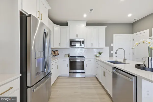 a kitchen with stainless steel appliances granite countertop a refrigerator stove and sink
