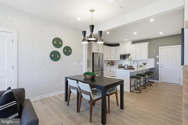 a dining room with kitchen island stainless steel appliances furniture a dining table and chairs