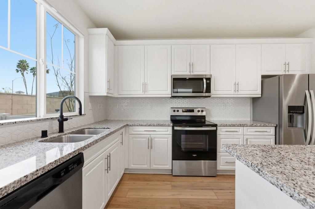 2711 Jujube Street Spring Valley, CA 91977 - Photo 11 of 31 a kitchen with stainless steel appliances granite countertop a sink stove and refrigerator