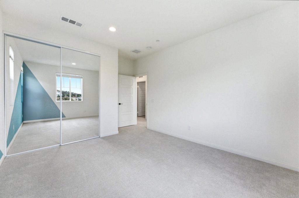 2711 Jujube Street Spring Valley, CA 91977 - Photo 15 of 31 an empty room with a mirror and a ceiling fan