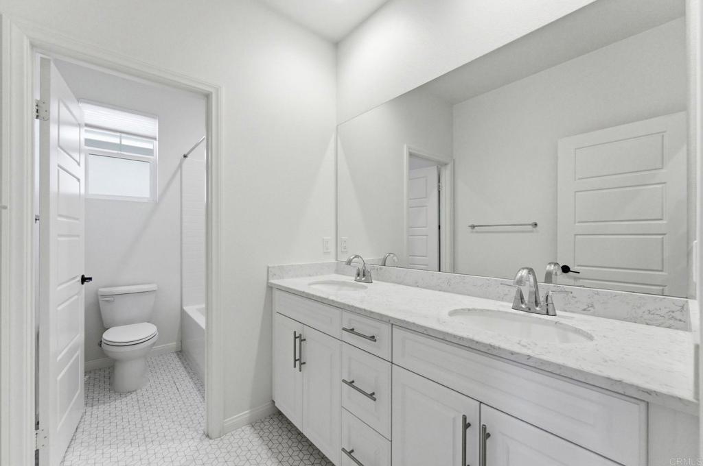 2711 Jujube Street Spring Valley, CA 91977 - Photo 23 of 31 a bathroom with a granite countertop sink a toilet and a mirror