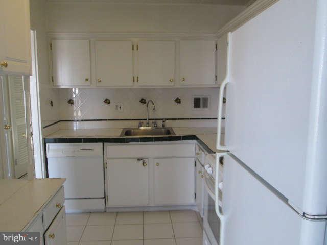 2624 Fort Farnsworth Road, Unit 209 Alexandria, VA 22303 - Photo 11 of 19 a kitchen with granite countertop white cabinets and white appliances