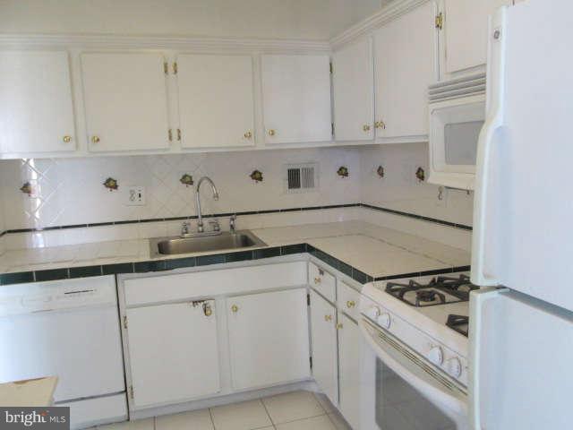 2624 Fort Farnsworth Road, Unit 209 Alexandria, VA 22303 - Photo 12 of 19 a kitchen with granite countertop white cabinets and white appliances