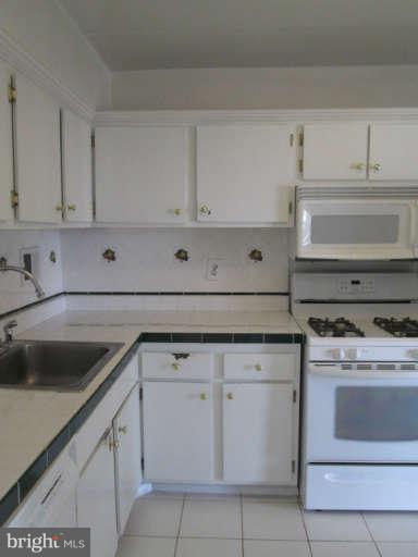 2624 Fort Farnsworth Road, Unit 209 Alexandria, VA 22303 - Photo 8 of 19 a kitchen with white cabinets and white appliances