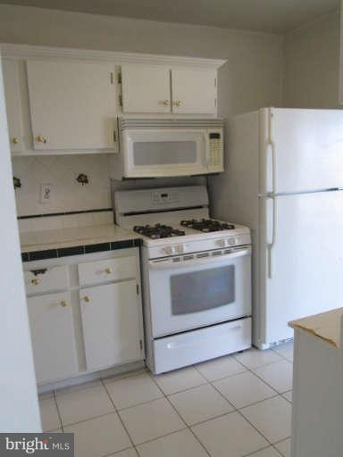 2624 Fort Farnsworth Road, Unit 209 Alexandria, VA 22303 - Photo 9 of 19 a kitchen with white cabinets and white appliances