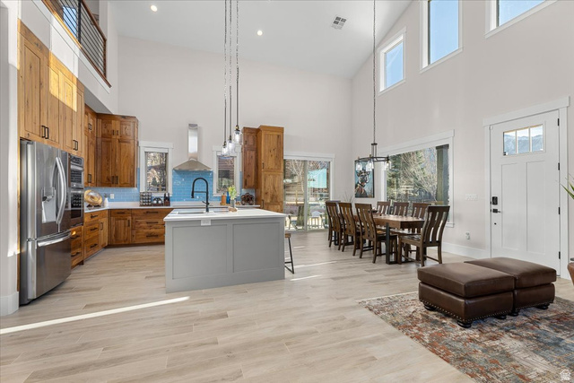 1210 East Bristle Cone Road Pine Valley, UT 84781 - Photo 8 of 54 Kitchen featuring a center island with sink, stainless steel fridge, a kitchen bar, hanging light fixtures, and light wood-like tile flooring