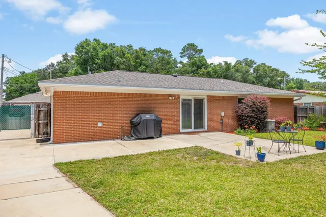 a front view of house with yard and trees in the background