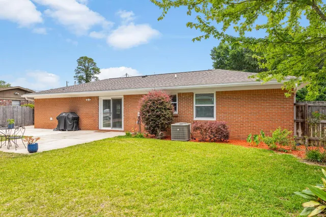 a view of a house with backyard and trees