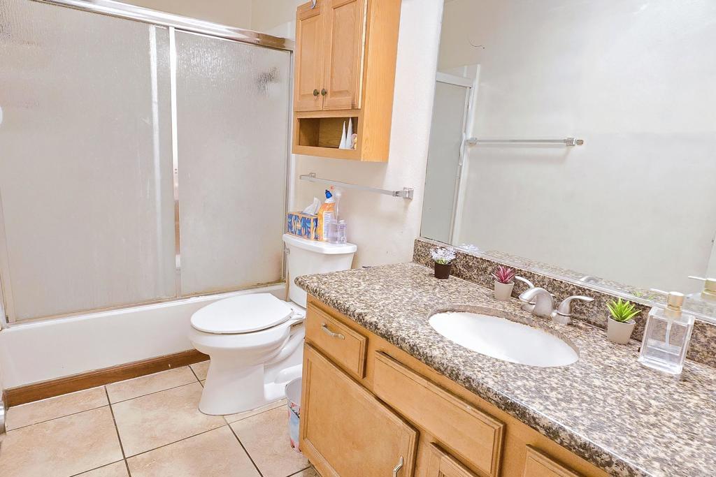 505 East Madison Avenue, Unit 70 El Cajon, CA 92020 - Photo 11 of 13 a bathroom with a granite countertop sink a toilet and a mirror