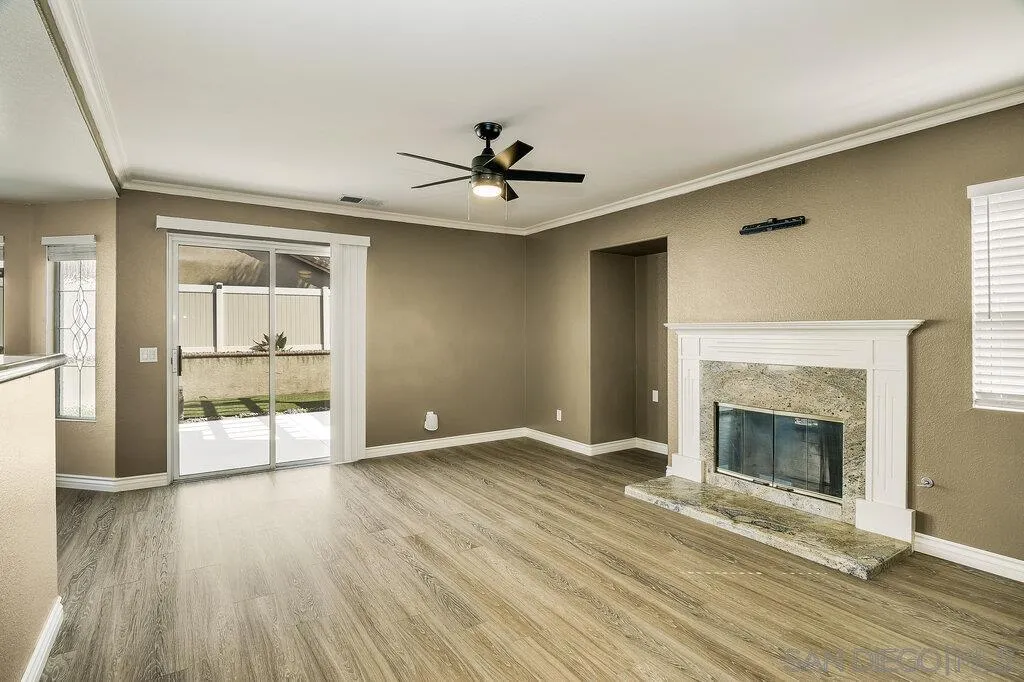 11212 Callio Way Lakeside, CA 92040 - Photo 15 of 50 an empty room with wooden floor fireplace and windows