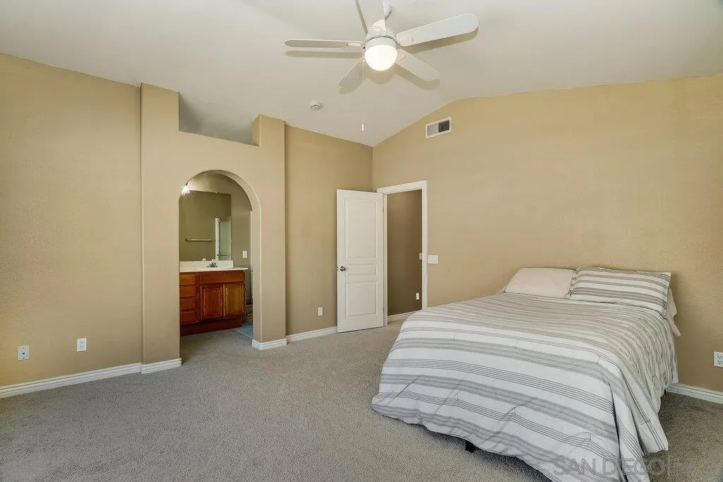 11212 Callio Way Lakeside, CA 92040 - Photo 21 of 50 a spacious bedroom with a bed and a chandelier