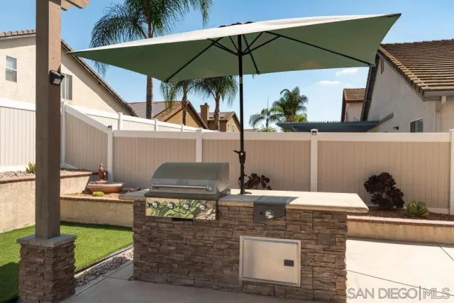 a view of a patio with table and chairs under an umbrella