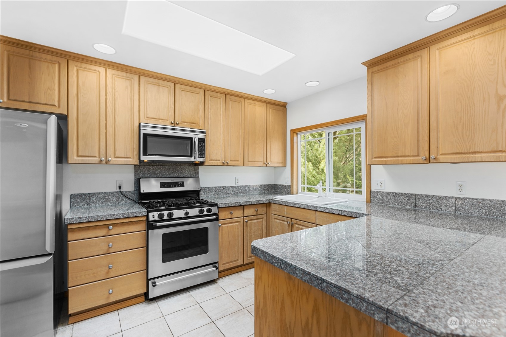 24216 13th Place West Bothell, WA 98021 - Photo 13 of 37 a kitchen with granite countertop a stove top oven sink and cabinets