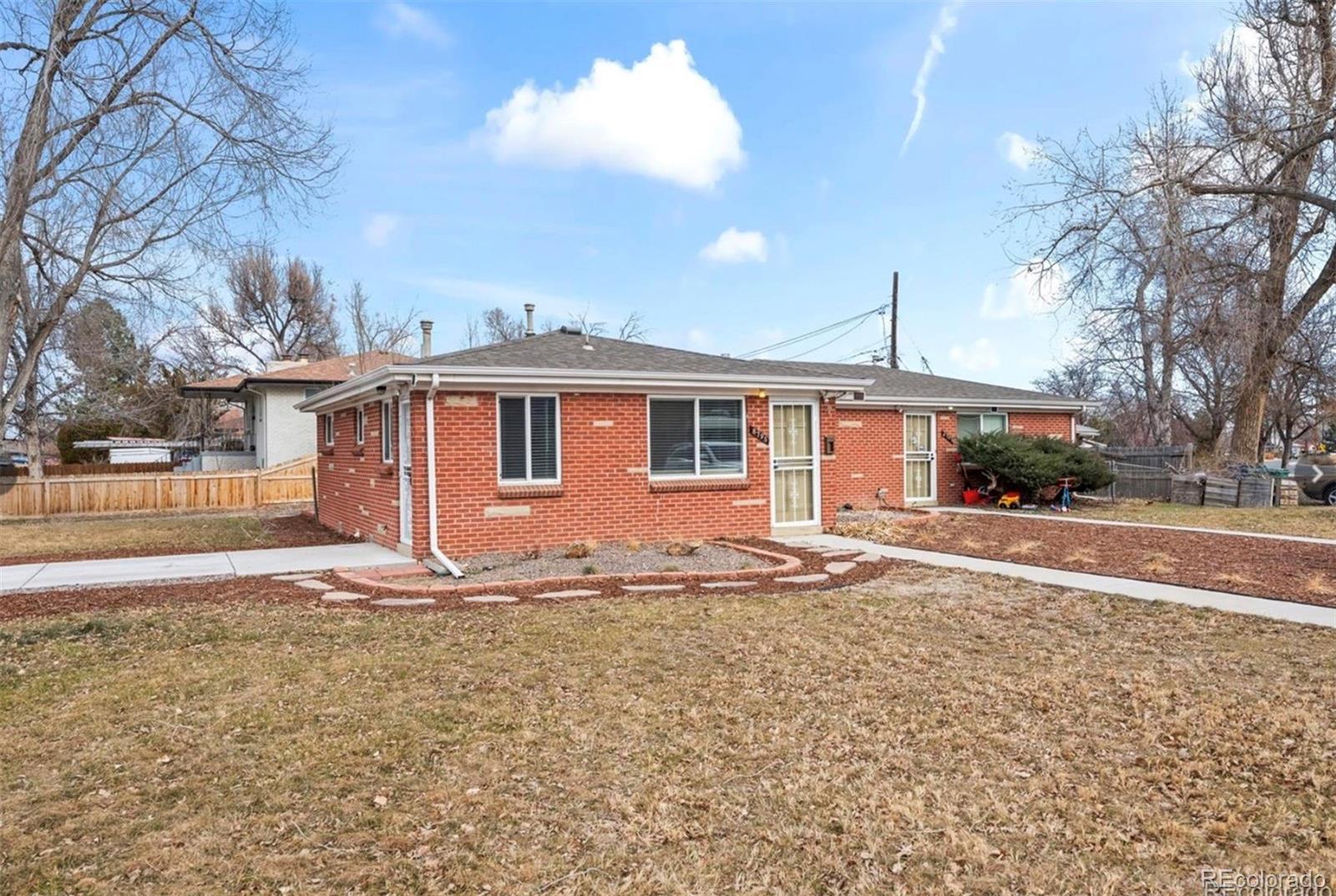 8795 West 46th Avenue Wheat Ridge, CO 80033 - Photo 2 of 12 a front view of a house with a yard