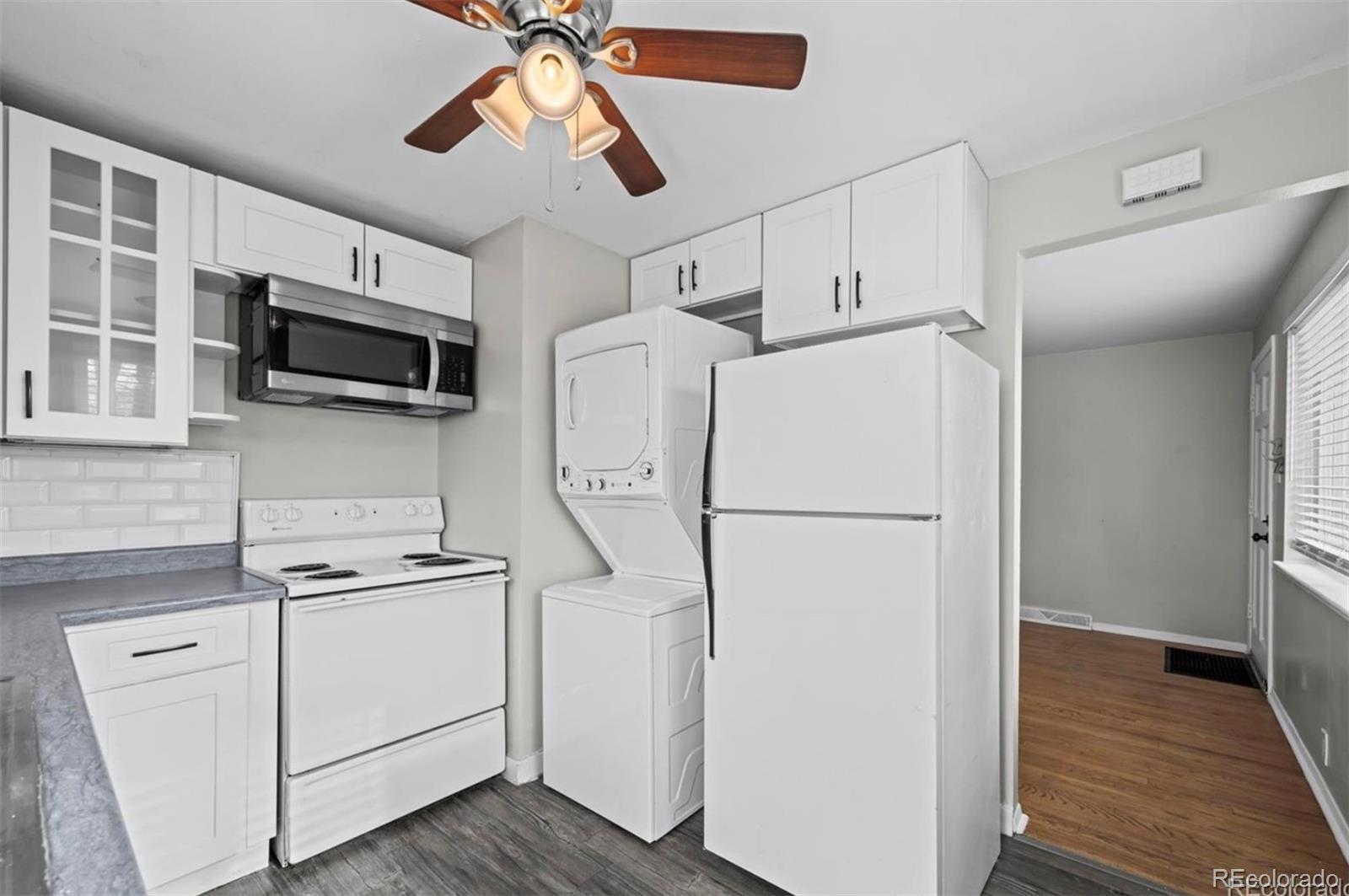 8795 West 46th Avenue Wheat Ridge, CO 80033 - Photo 4 of 12 a white refrigerator freezer and a stove sitting inside of a kitchen