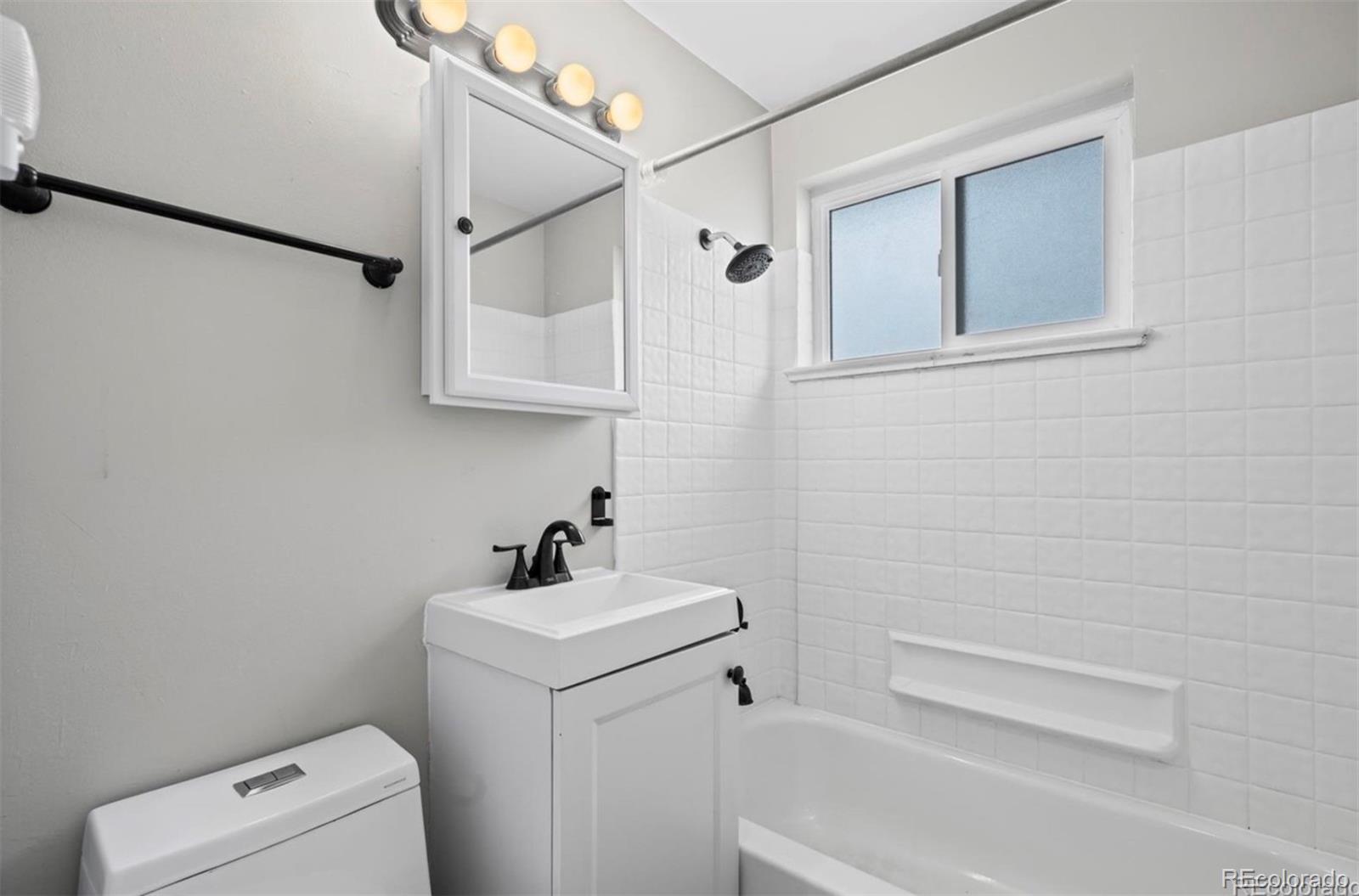 8795 West 46th Avenue Wheat Ridge, CO 80033 - Photo 6 of 12 a bathroom with a sink a toilet and shower