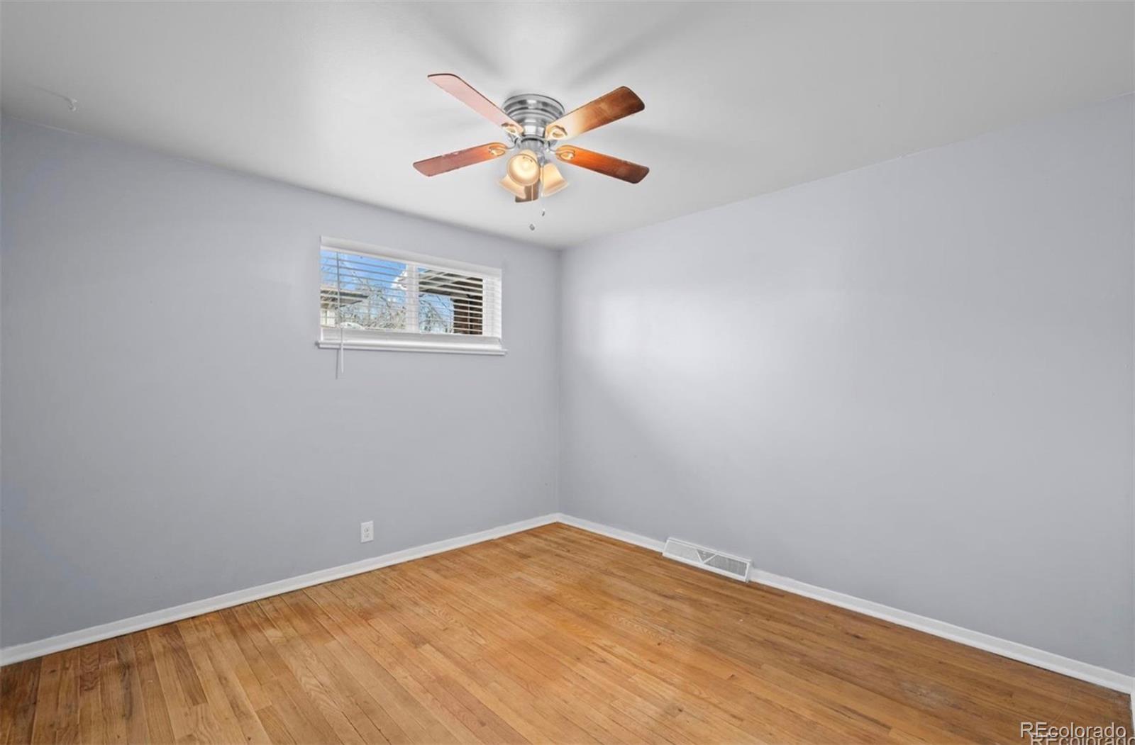 8795 West 46th Avenue Wheat Ridge, CO 80033 - Photo 7 of 12 an empty room with a window and a ceiling fan