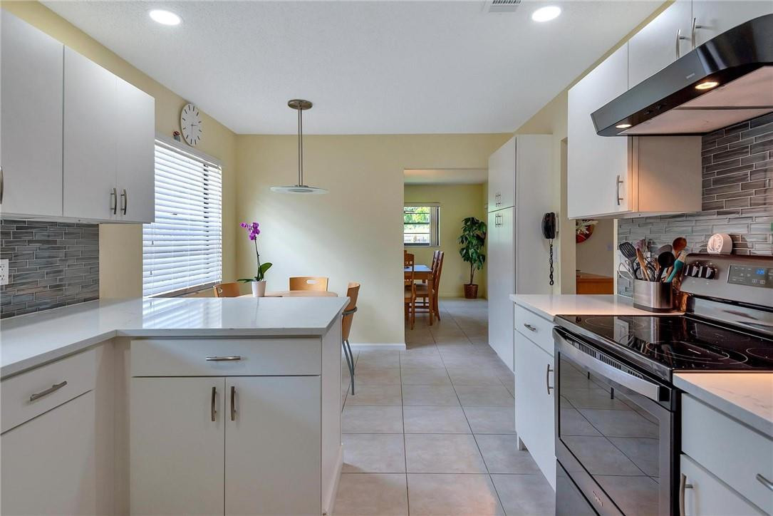 23090 Southwest 56th Avenue Boca Raton, FL 33433 - Photo 17 of 49 a kitchen with kitchen island a sink appliances and cabinets
