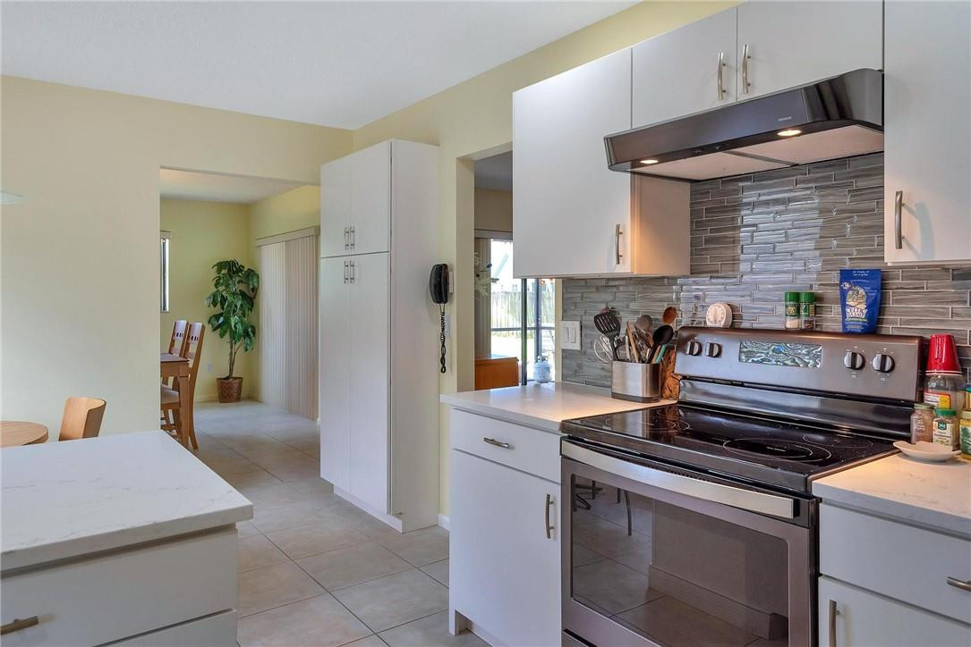 23090 Southwest 56th Avenue Boca Raton, FL 33433 - Photo 18 of 49 a kitchen with stainless steel appliances a stove and a refrigerator
