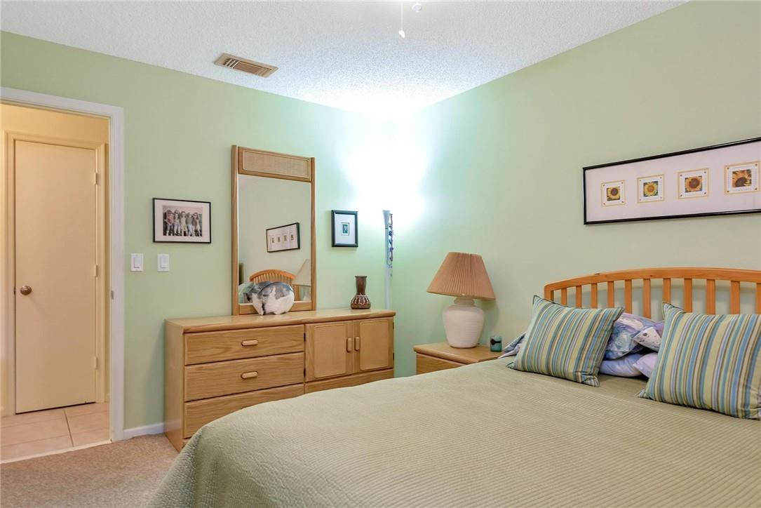 23090 Southwest 56th Avenue Boca Raton, FL 33433 - Photo 31 of 49 a bedroom with a bed and a lamp on dresser