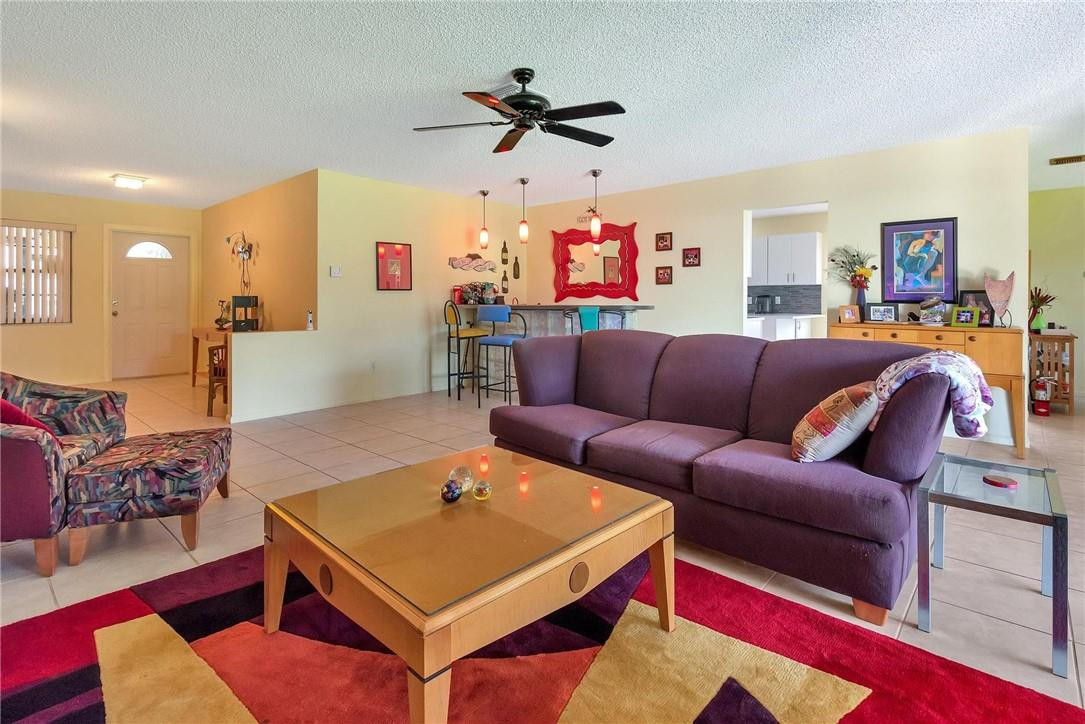 23090 Southwest 56th Avenue Boca Raton, FL 33433 - Photo 9 of 49 a living room with furniture a rug and a chandelier
