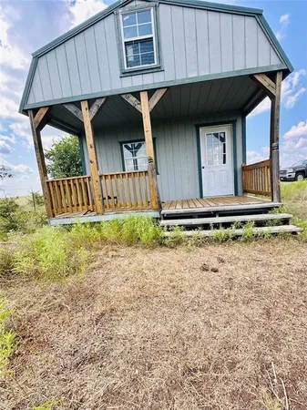 a view of a house with backyard and wooden fence