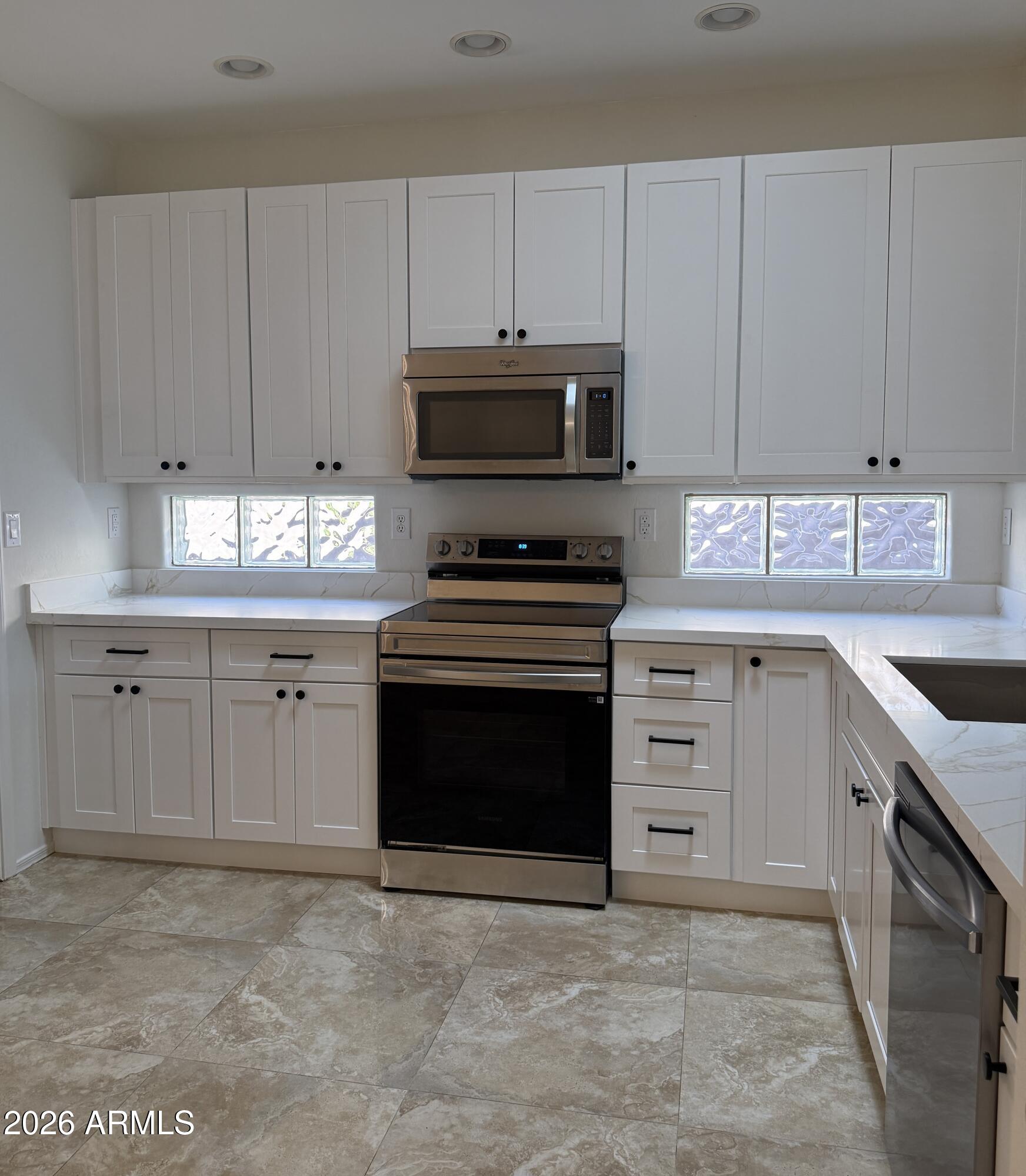 41915 North Crooked Stick Road Anthem, AZ 85086 - Photo 4 of 29 a kitchen with granite countertop a stove top oven and cabinets