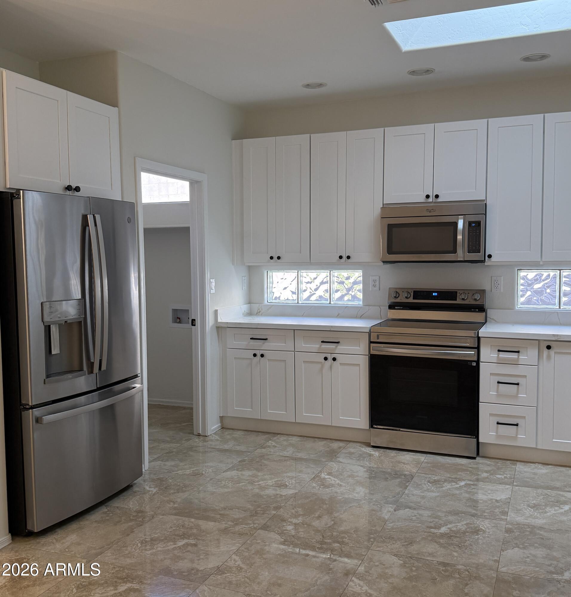 41915 North Crooked Stick Road Anthem, AZ 85086 - Photo 5 of 29 a kitchen with granite countertop a refrigerator stove and microwave