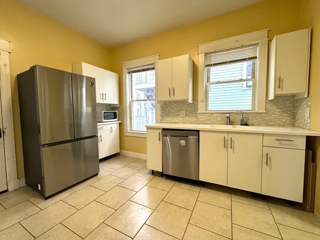 a kitchen with a refrigerator sink and cabinets