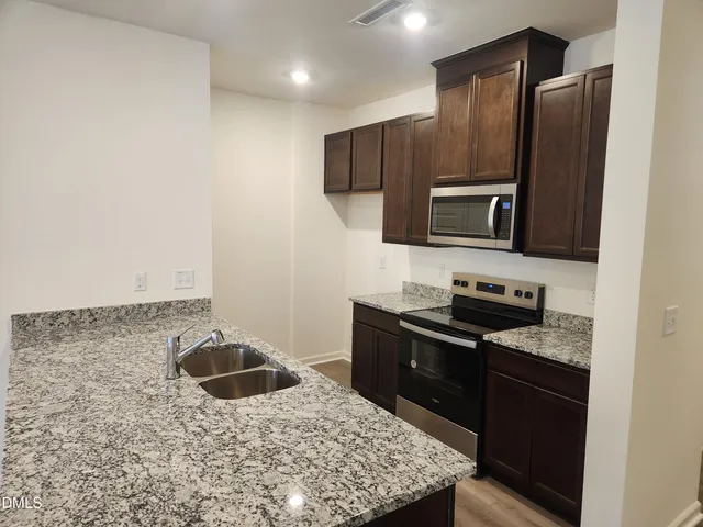 a kitchen with a sink stove and refrigerator