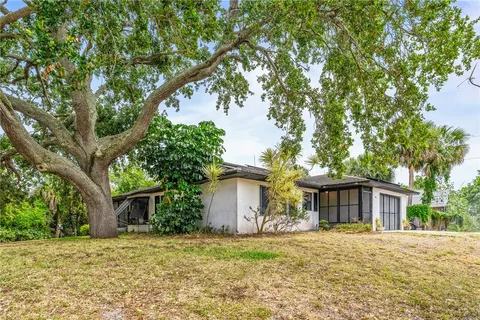 a front view of a house with a garden and trees