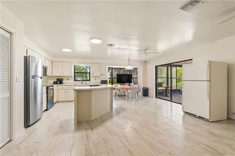 a kitchen with white cabinets and refrigerator