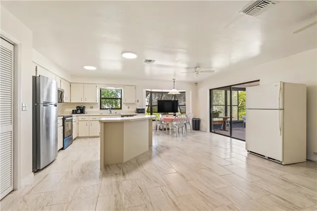 a kitchen with white cabinets and refrigerator