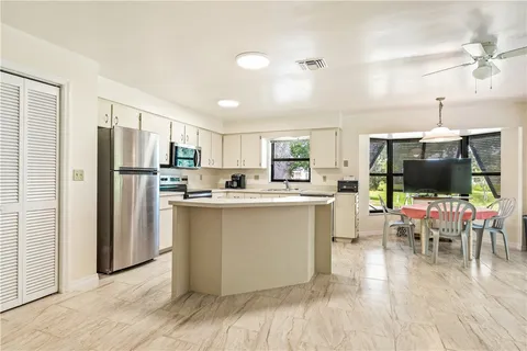 a kitchen with stainless steel appliances a refrigerator and a dining table