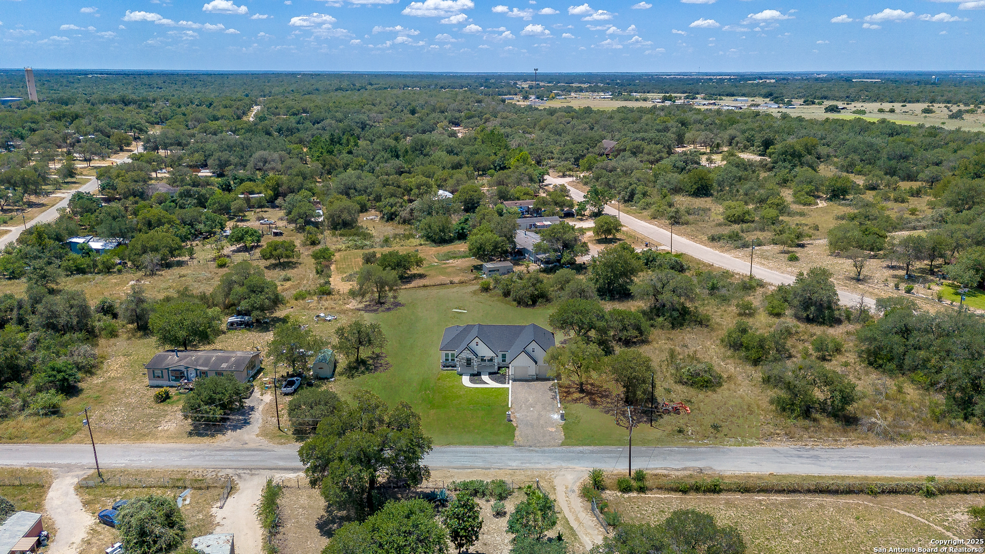 120 County Road 6852 Lytle, TX 78052 - Photo 35 of 36 an aerial view of residential houses with outdoor space and trees
