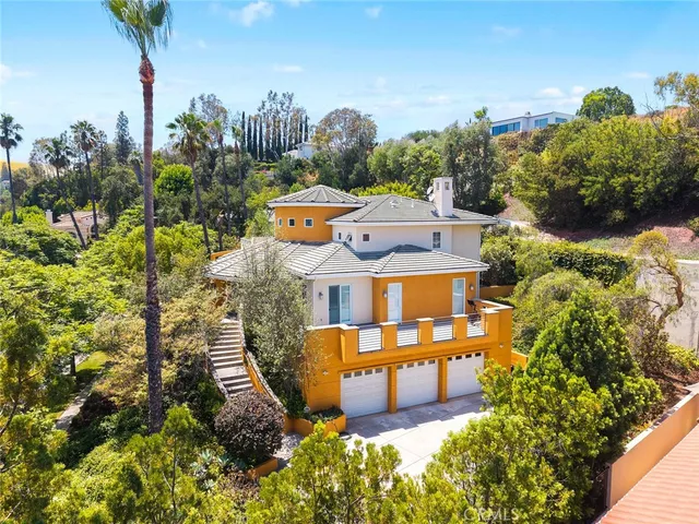 an aerial view of a house with a garden and trees