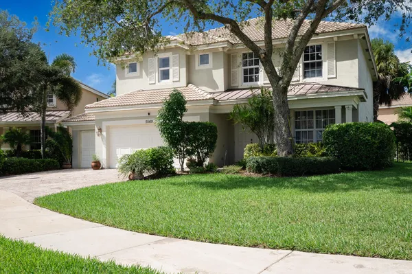 a front view of a house with a garden and plants