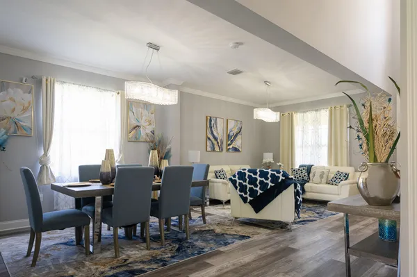 a kitchen with stainless steel appliances kitchen island granite countertop a table chairs and a refrigerator