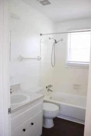 a bathroom with a granite countertop sink a toilet and shower
