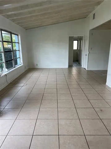 a view of a livingroom with an empty space and a window