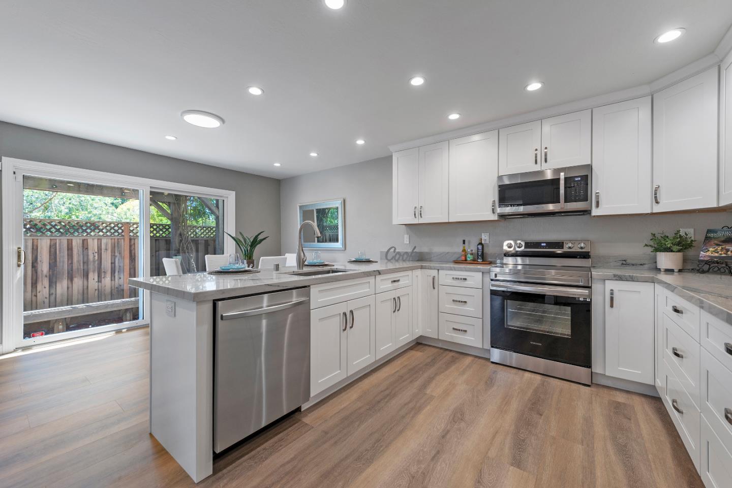 334 West Rincon Avenue Campbell, CA 95008 - Photo 10 of 25 a kitchen with granite countertop a stove top oven sink and cabinets
