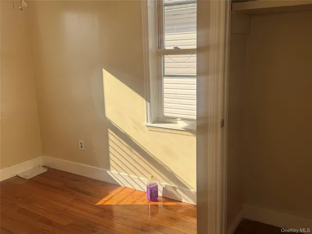 a view of a hallway with wooden floor and windows
