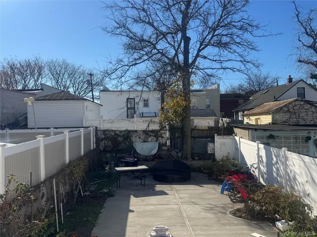 a backyard of a house with barbeque oven and outdoor seating