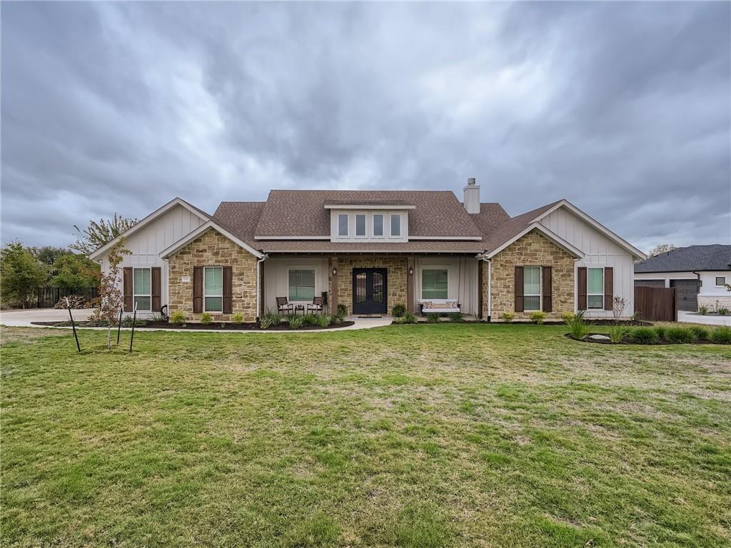 132 Huerta Road Florence, TX 76527 - Photo 40 of 40 A graceful home featuring stone and siding construction, set against a manicured front lawn and mature landscaping.