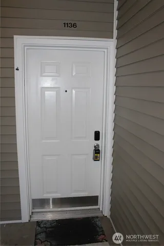 a view of an empty room with window and fire place