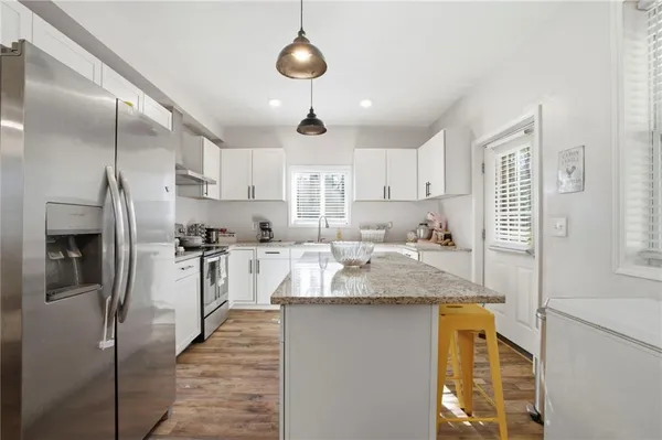 a kitchen with stainless steel appliances granite countertop a sink stove and refrigerator