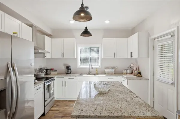 a kitchen with granite countertop a sink stove and cabinets