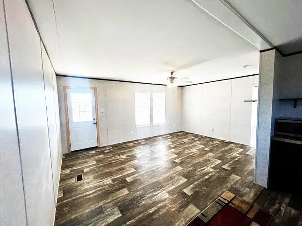 a view of a room with wooden floor and white walls