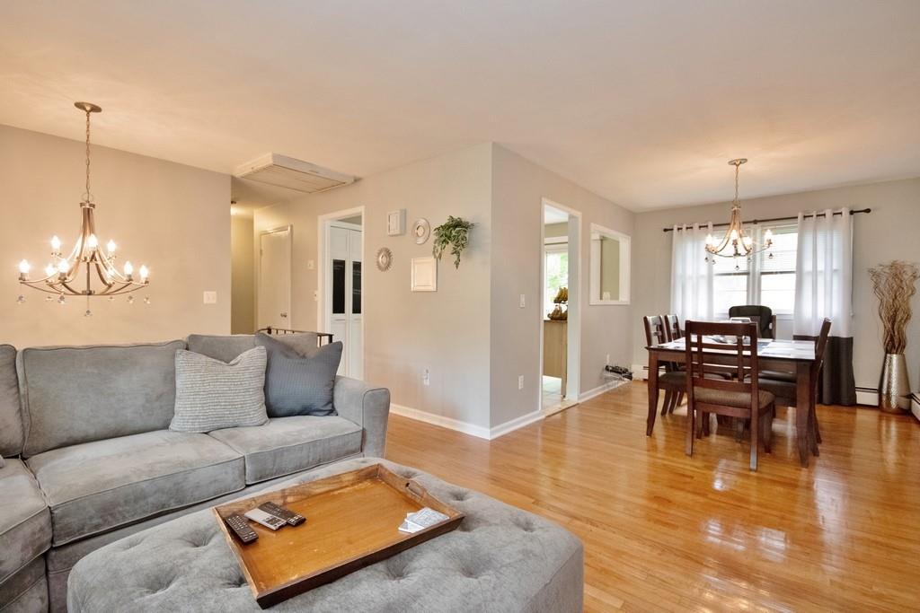 1775 Lakes Road Monroe, NY 10950 - Photo 1 of 1 Living area with a chandelier, light wood-style floors, and baseboards