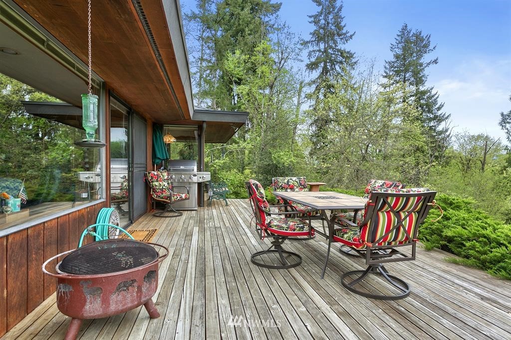 22016 High Bridge Road Monroe, WA 98272 - Photo 26 of 40 a view of a patio with table and chairs potted plants with wooden floor and fence